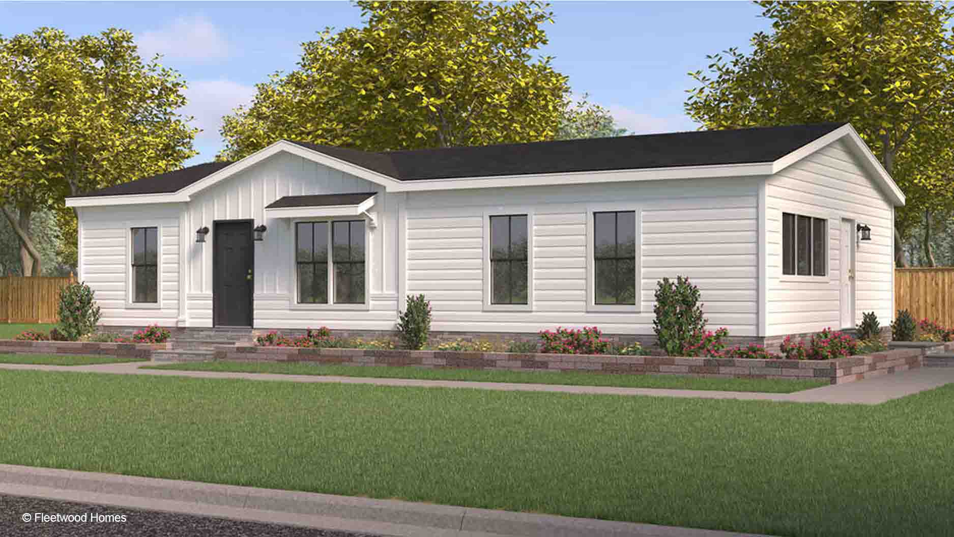 A modern white single-story manufactured home with large windows, a black roof, and a landscaped front yard.
